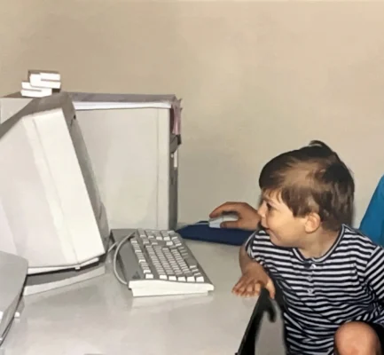 Young Theo, fascinated by a CRT monitor, sitting with his mom at their first second-hand Pentium II PC (late 90s).