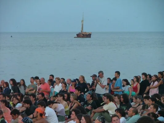 Large crowd gathered on Vama Veche beach in 2003, with the Akra Aktion wreck still visible offshore.