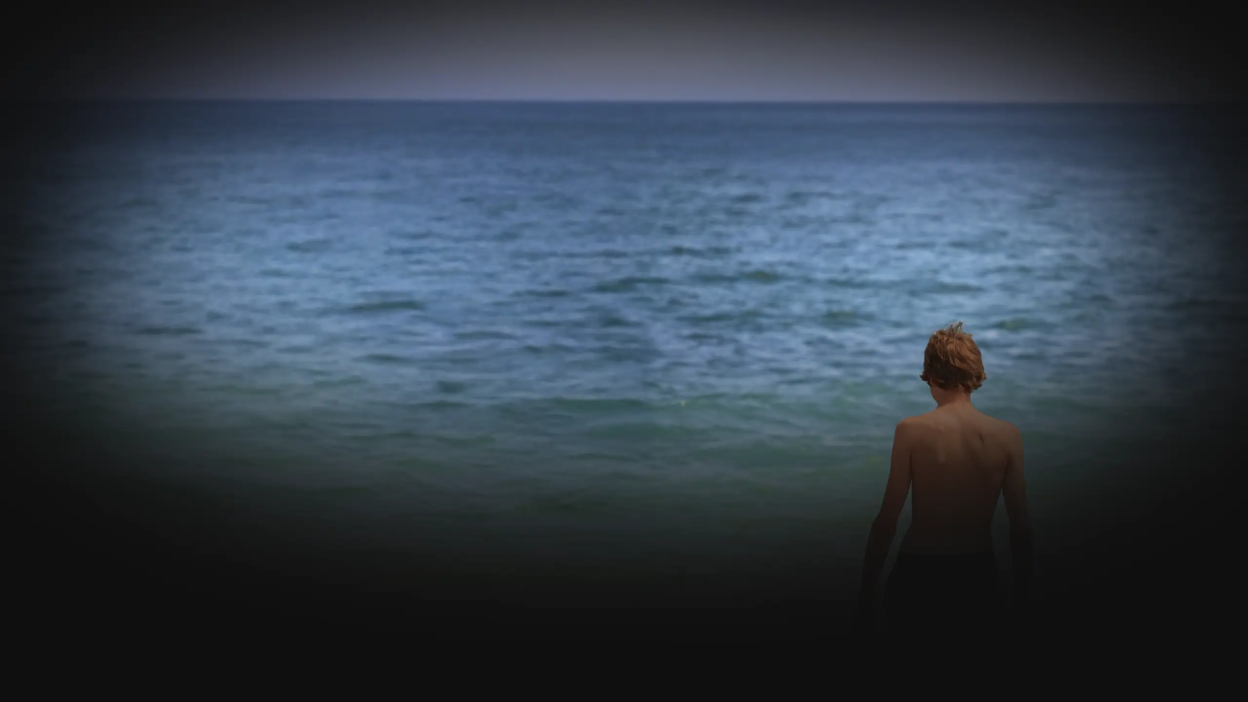 Teenager at Vama Veche beach, standing before the Black Sea horizon.