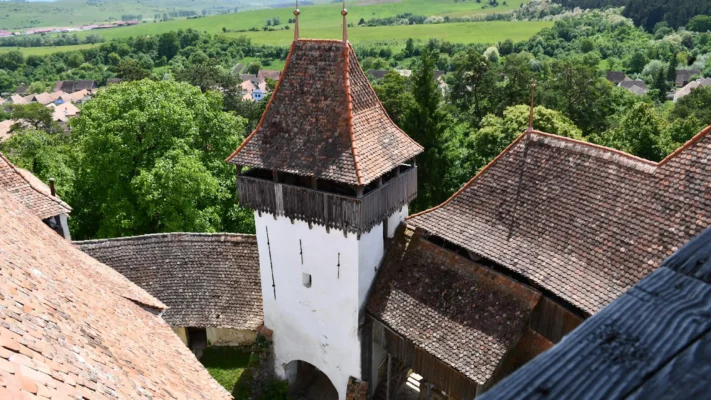 View from Viscri fortified church across its defensive tower and the rolling green hills of southern Transylvania.