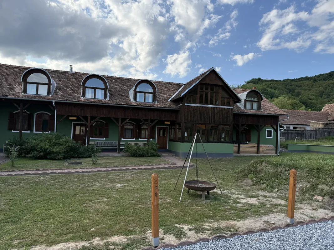 Interior courtyard of Reussdorfer Hof in Cund, with green-painted walls, timber verandas, attic dormers and a fire pit.