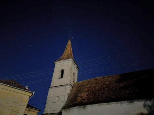 Abandoned church of Cund illuminated beneath a starry night sky.