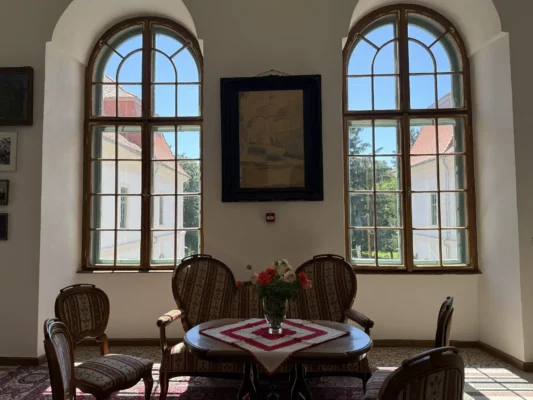 Period seating beside tall arched windows inside Teleki Castle in Gornești