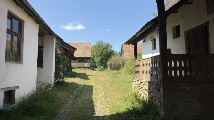 Traditional Saxon courtyard in Viscri with whitewashed houses, wooden verandas and red-tiled roofs.